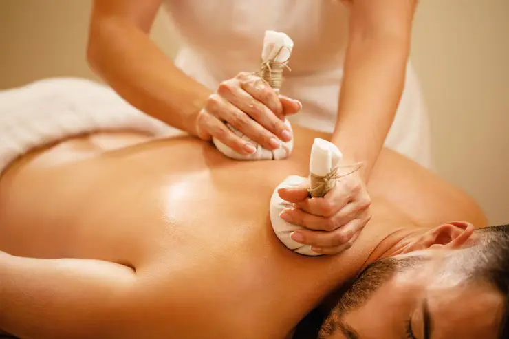 man-getting-back-massage-with-detox-herbal-balls